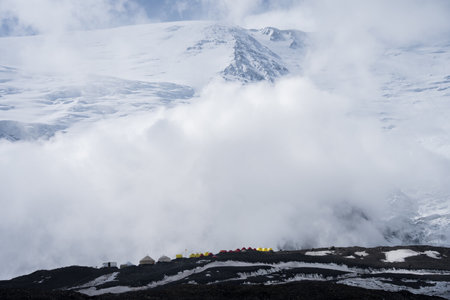 High altitude tents campsite with huge snowy mountain in backdrop, Pamir Mountains, Kyrgyzstanの写真素材