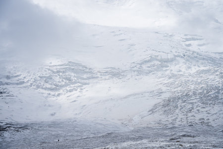 Huge glacier landscape with tiny mountaineer for scale in front of it , Pamir Mountains, Kyrgyzstan