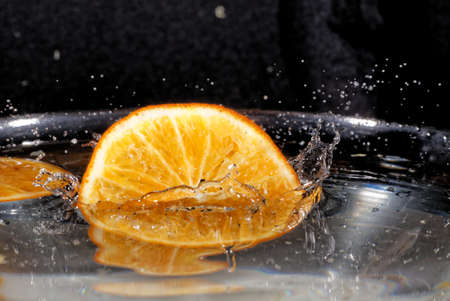 Slice of orange in waterの写真素材