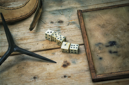 Roman bone dice on a table, by a wax writing tablet.のeditorial素材
