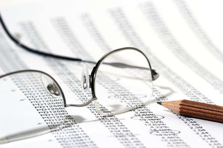 Sales Report in listform with marked data, brown pencil and eyeglassesの写真素材