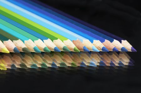 Colored crayonson a mirrow in a row in rainbow colorsの写真素材