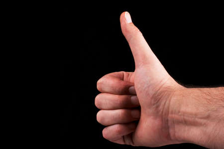 to keep one's fingers crossed for someone - black backgroundの写真素材