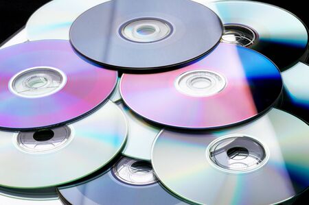 Many colorful DVD lying upon each other - landscape formatの写真素材