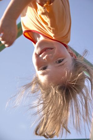child on climbing pole - head first and laughing