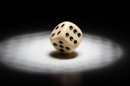 Dice in the spotlight - black backgroundの写真素材