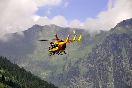 Rescue helicopter in the mountains lifting up の写真素材