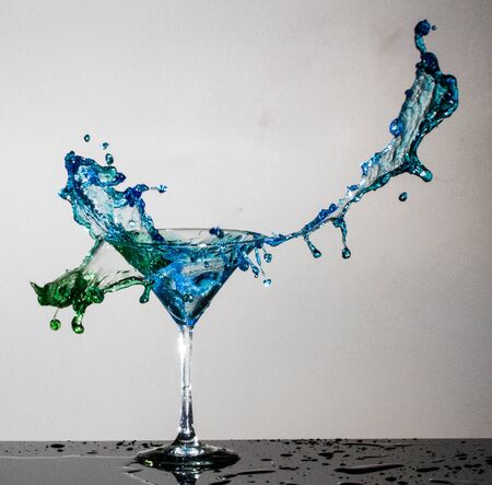 Cocktail splashing into martini glassの写真素材