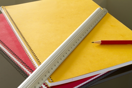 closed notebooks with pencil and slat