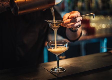 Landscape photo of bartender mixing a cocktail at a moody cocktail barの写真素材