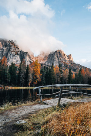 Autumn colours of Lake Lago dAntorno and bridge in Dolomites Italyの写真素材