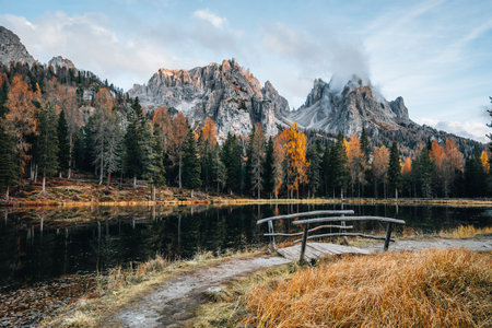 Autumn colours of Lake Lago dAntorno and bridge in Dolomites Italyの写真素材