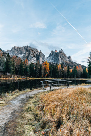 Autumn colours of Lake Lago dAntorno and bridge in Dolomites Italyの写真素材