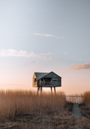 Sunset photo of Kiekkaaste Bird Observatory in The Netherlands at Wadden Seaの写真素材
