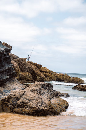 Fisherman at south west coast of Portugal on the beach, next to Atlantic Oceanの写真素材