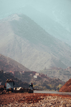 Winding roads through the Atlas Mountains in Morocco with single person walkingの写真素材