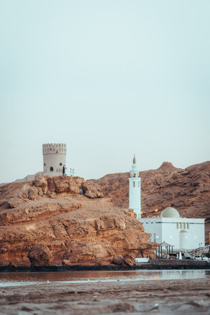 View on the mosque and watch tower in coast town Sur, Oman during sunset