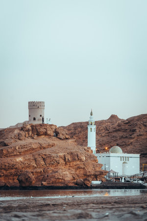 View on the mosque and watch tower in coast town Sur, Oman during sunsetの写真素材