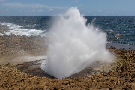 Sea water erupting from the blow holeの写真素材