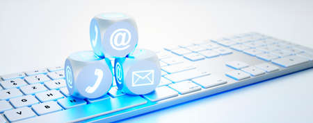 Three dice with communication symbols on white computer keyboard - 3D illustrationの写真素材