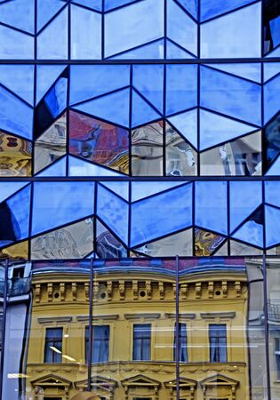 Reflection of an historic building in the glass wall of a modern building in pragueの写真素材