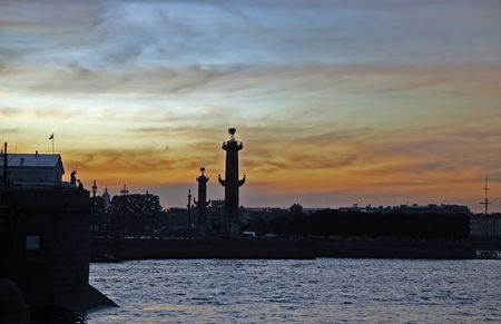 White nights. View of the Neva river and silhouettes of Rostral columns and part of the Palace bridge against the sunset. St. Petersburg, Russia.の写真素材