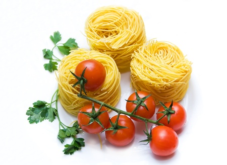 Fresh tomato cherry, parsley and spaghetti against white background. の写真素材