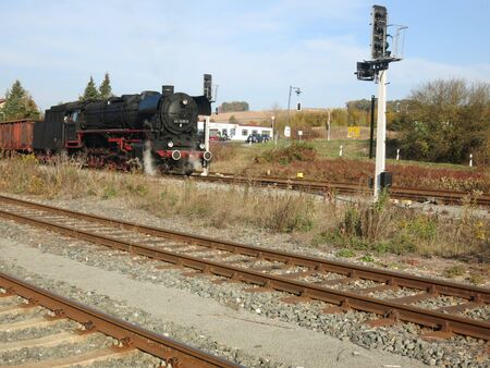 Freight train with steam locomotive ready to go at the station