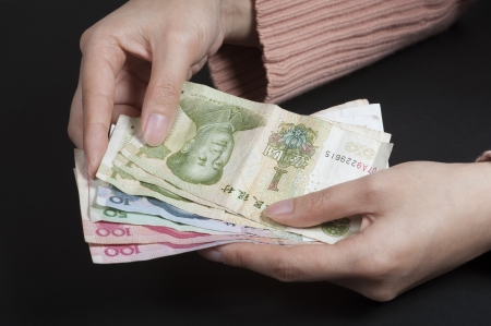 Female hands counting Chinese banknotesの写真素材