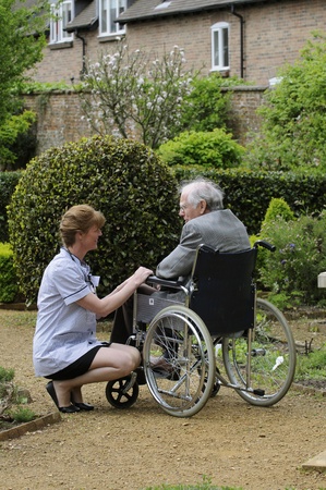 Nurse caring for man sitting in a wheelchairの写真素材