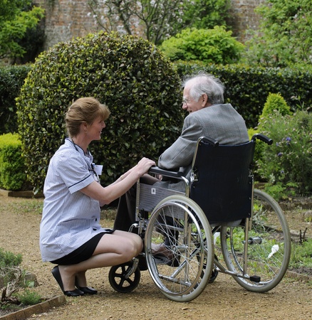 Nurse caring for man sitting in a wheelchairの写真素材
