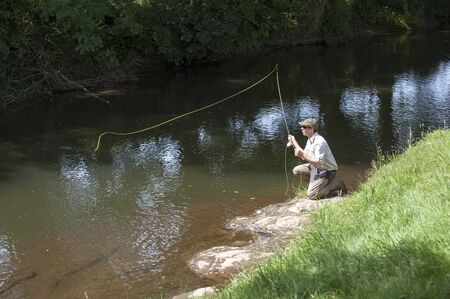 Man fly fishing on River Lyd Devon UKの写真素材