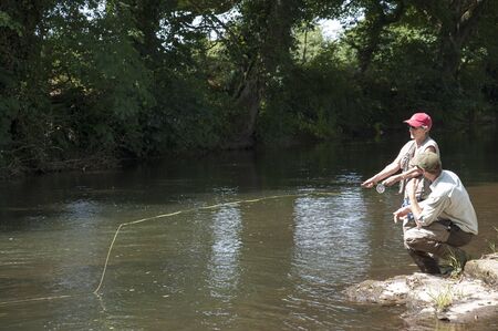 Fly fishing a gillie instructing a pupil River Lyd Devon UKの写真素材