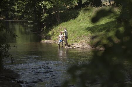 Fly fishing a gillie instructing a pupil River Lyd Devon UKの写真素材