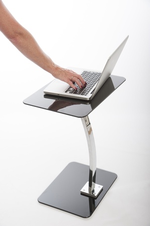 Woman using a laptop computer on a glass tableの写真素材