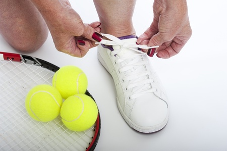 Female tennis player tying shoe laceの写真素材