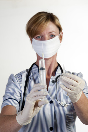 Nurse in surgical gloves holding syringeの写真素材