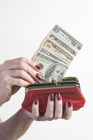 Red purse woman holding US dollarsの写真素材