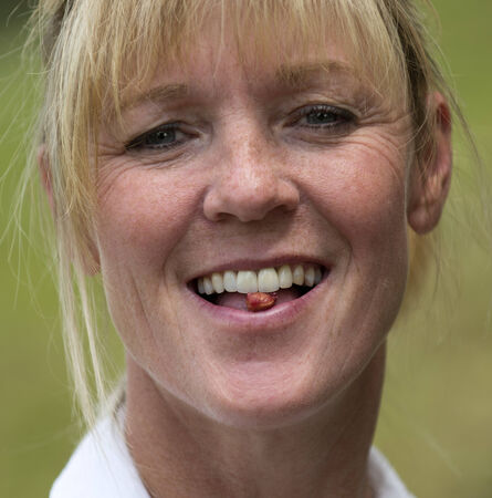 Portrait of a woman with a cherry stone between her front teeth