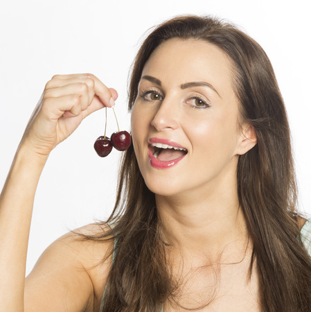 Attractive woman eating cherries