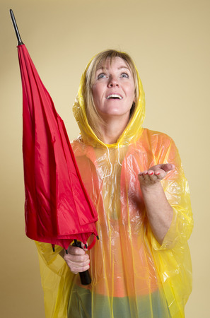 Woman in Poncho holding an umbrellaの写真素材