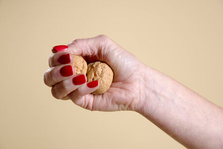 Walnuts in a woman's hand being crushed