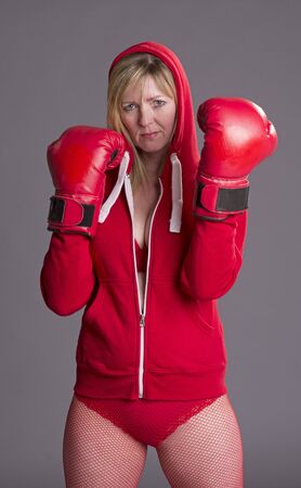 Woman fighting fit and wearing red boxing glovesの写真素材