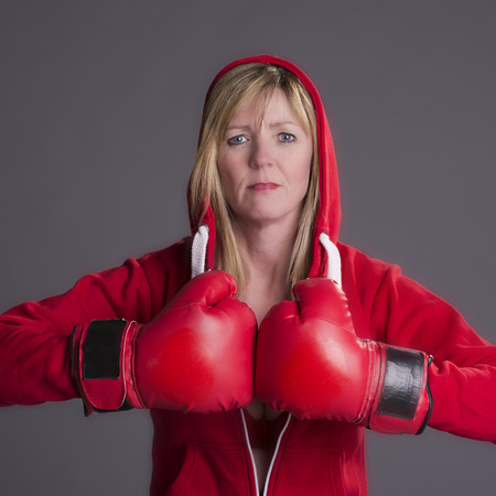 Woman fighting fit and wearing red boxing glovesの写真素材