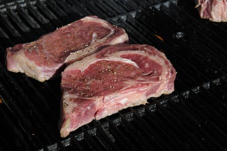 Ribeye steaks cooking on a gas barbeque