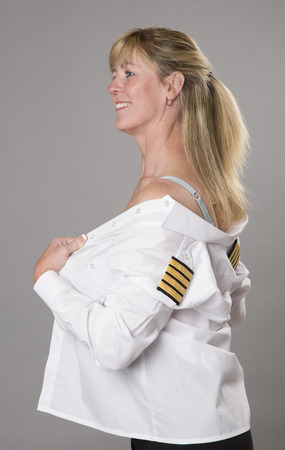 Woman officer getting dressed into uniform shirtの写真素材