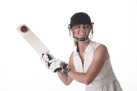 Woman hitting cricket ball with a batの写真素材