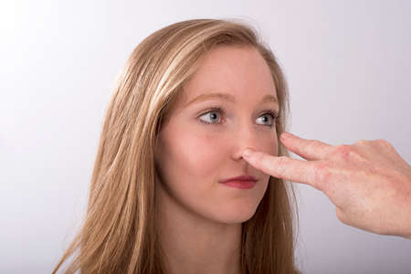 A two fingure gesture towards a young woman's eyesの写真素材