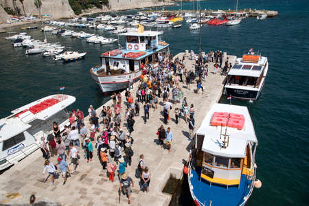 OLD HARBOR DUBROVNIK CROATIA - MAY 2016 - Tourists mingle at the Old Harbor in Dubrovnik where small ferry boats arrive and depart to outlaying islandsのeditorial素材