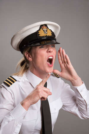 OFFICER SHOUTS AN ORDER MAY 2016 - Portrait of a female uniformed officer shouting and pointing her forefingerの写真素材